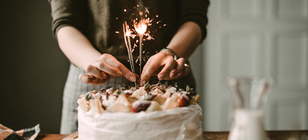 Dame pynter kake med lys. Fond i gave