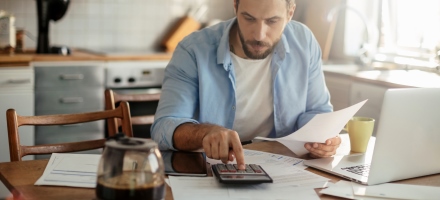 Mann regner med kalkulator