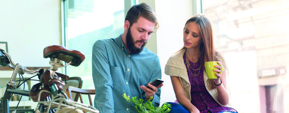 mann og kvinne p kafe ser p telefon