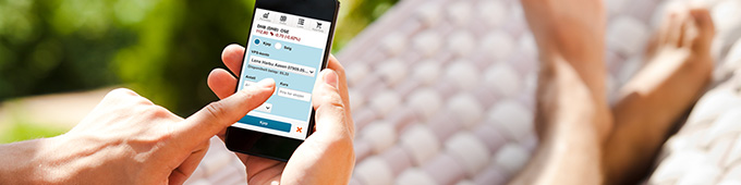 Bilde av mann som sitter med mobil aksjehandel i hengekye